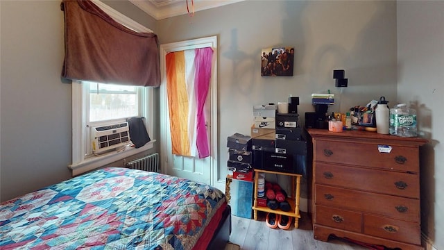 bedroom with radiator heating unit and light wood-type flooring