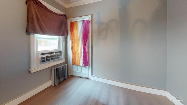 empty room featuring radiator heating unit and light hardwood / wood-style flooring