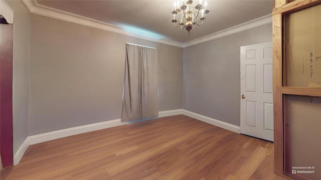 spare room featuring ornamental molding, a chandelier, and wood-type flooring