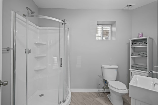 bathroom with walk in shower, vanity, toilet, and hardwood / wood-style flooring