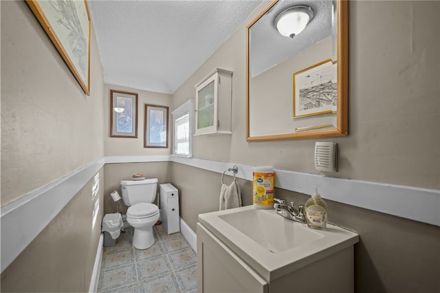 bathroom with vanity, a textured ceiling, and toilet