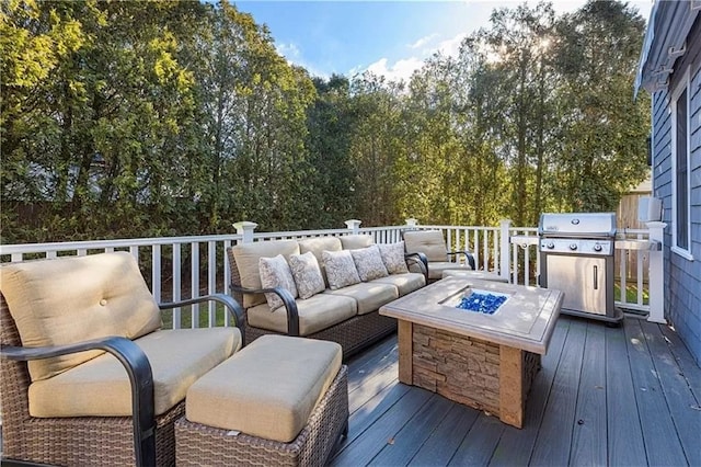 deck featuring a grill and an outdoor living space with a fire pit