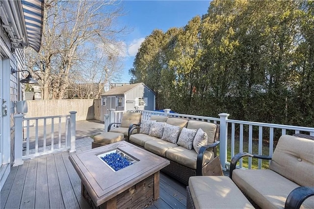 wooden terrace with a shed and an outdoor living space with a fire pit