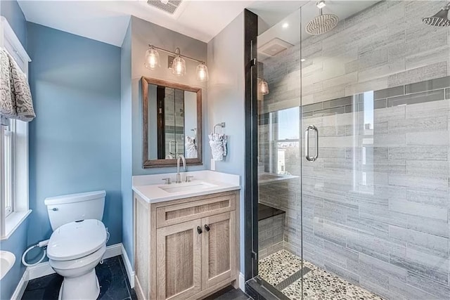 bathroom featuring vanity, toilet, and a shower with shower door