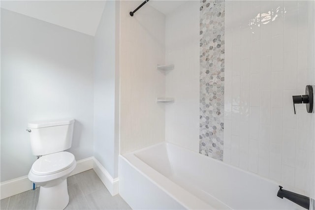 bathroom featuring tiled shower / bath combo and toilet