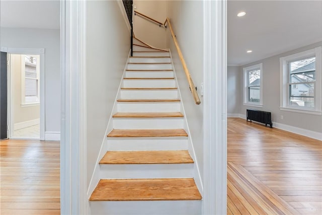 staircase featuring radiator heating unit and wood-type flooring