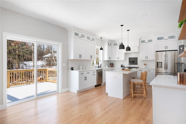 kitchen with a kitchen island, white cabinets, and appliances with stainless steel finishes