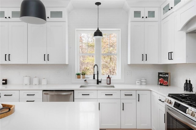 kitchen featuring white cabinetry, stainless steel appliances, decorative light fixtures, and sink