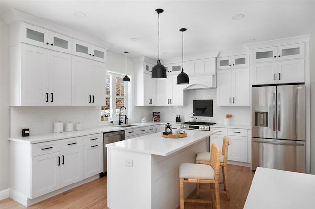 kitchen featuring a breakfast bar, white cabinetry, a kitchen island, pendant lighting, and stainless steel appliances