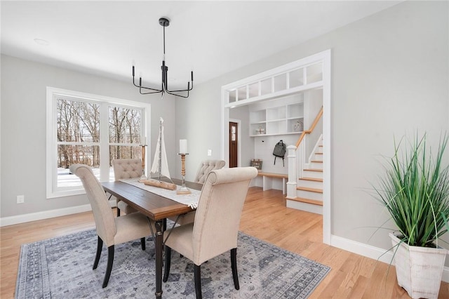 dining area with hardwood / wood-style flooring and a notable chandelier