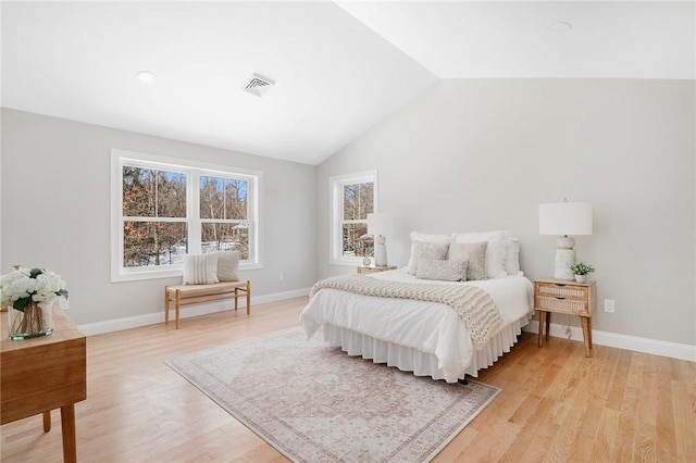 bedroom with vaulted ceiling and light wood-type flooring