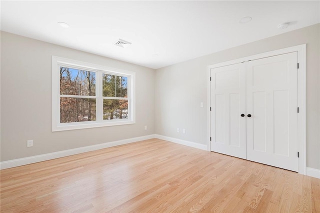 unfurnished bedroom featuring a closet and light wood-type flooring