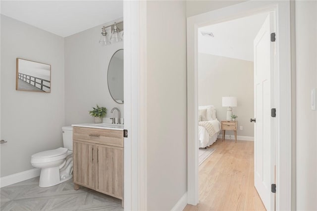 bathroom with hardwood / wood-style flooring, vanity, and toilet