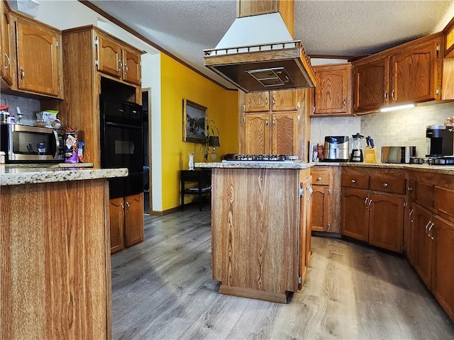 kitchen with island range hood, a center island, light hardwood / wood-style flooring, black oven, and backsplash