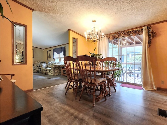 dining room with hardwood / wood-style flooring, crown molding, a notable chandelier, and a textured ceiling