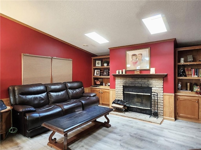 living room with a fireplace, light hardwood / wood-style floors, vaulted ceiling, and a textured ceiling