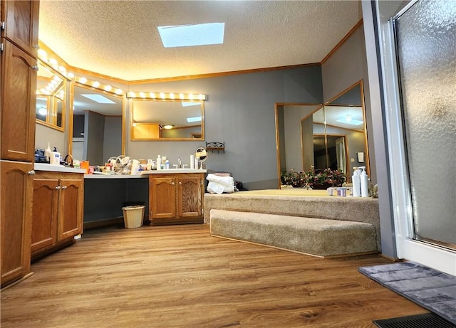 bathroom with an enclosed shower, crown molding, a textured ceiling, vanity, and hardwood / wood-style floors