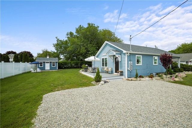 view of front facade featuring a patio, an outbuilding, and a front yard