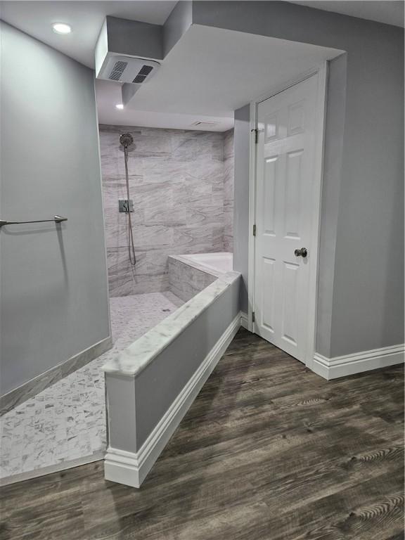 bathroom featuring tiled shower and hardwood / wood-style floors