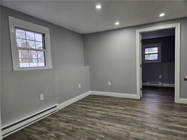 unfurnished room with a baseboard radiator and dark hardwood / wood-style flooring