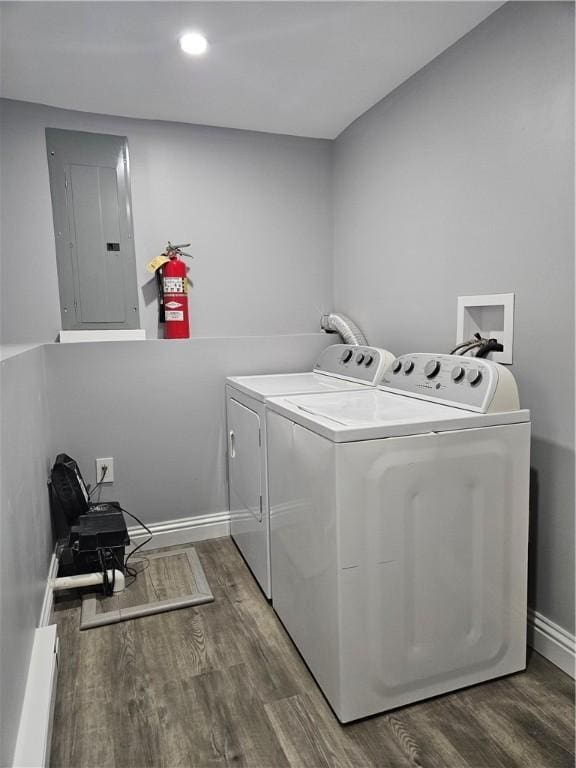 clothes washing area with hardwood / wood-style flooring, independent washer and dryer, and electric panel