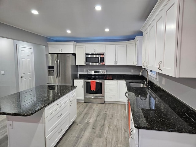 kitchen with sink, white cabinetry, a center island, light hardwood / wood-style flooring, and stainless steel appliances