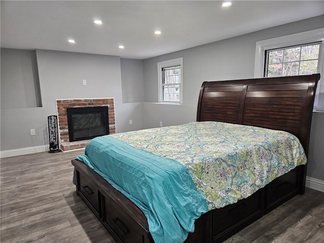 bedroom featuring wood-type flooring and a fireplace