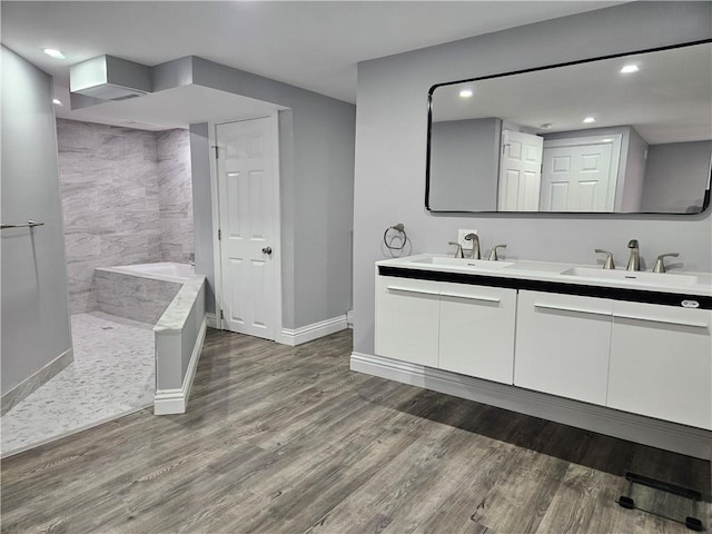 bathroom featuring hardwood / wood-style flooring, vanity, and a bath