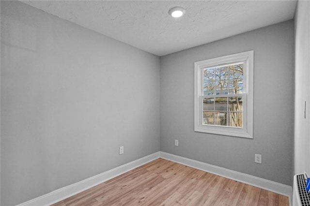 unfurnished room featuring light hardwood / wood-style floors and a textured ceiling