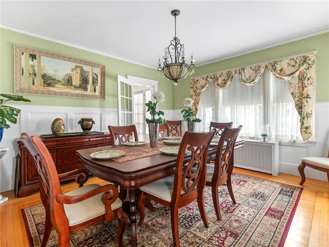 dining room with ornamental molding, plenty of natural light, radiator heating unit, and an inviting chandelier