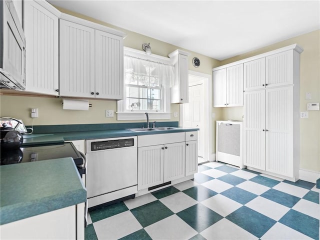 kitchen featuring dishwashing machine, sink, and white cabinetry