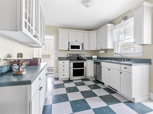 kitchen featuring white cabinetry, sink, stainless steel appliances, and a healthy amount of sunlight