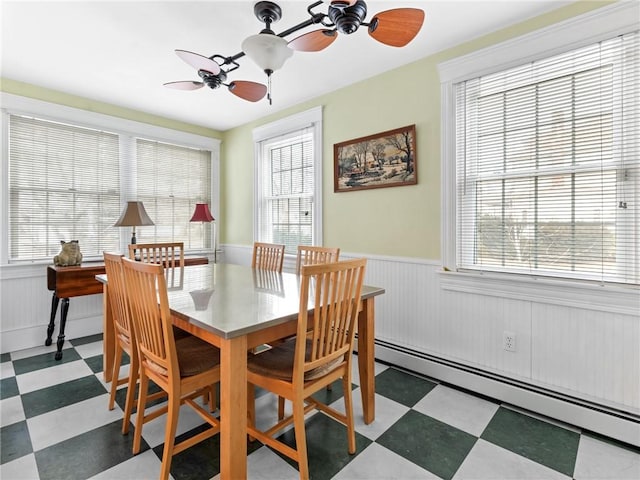 dining space with ceiling fan, a baseboard radiator, and a healthy amount of sunlight