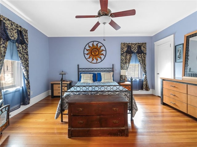 bedroom with ceiling fan, ornamental molding, and light wood-type flooring