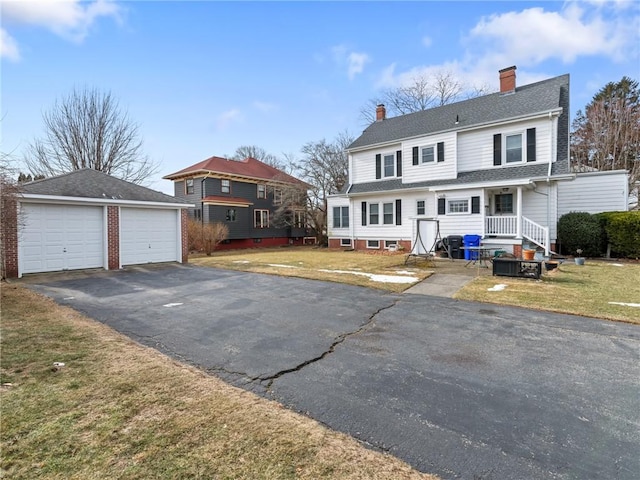 view of front facade with a garage, an outbuilding, and a front yard