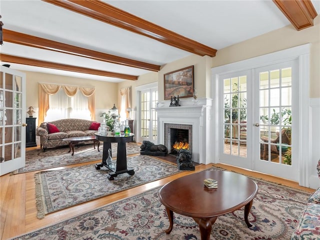 living room featuring beamed ceiling, wood-type flooring, and french doors