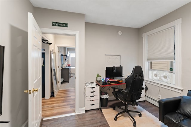 home office with a baseboard radiator and dark hardwood / wood-style floors