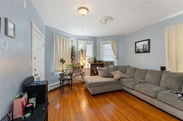 living room featuring cooling unit, a baseboard heating unit, a wealth of natural light, and wood-type flooring