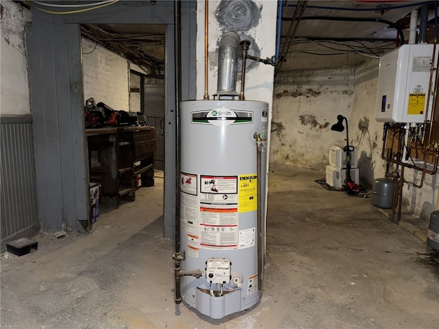 utility room featuring gas water heater and tankless water heater