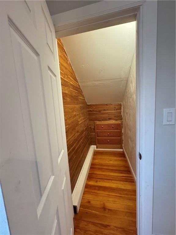 interior space with wood-type flooring, vaulted ceiling, and wooden walls