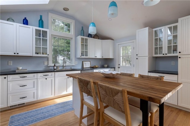 kitchen with white cabinetry, sink, pendant lighting, and a healthy amount of sunlight