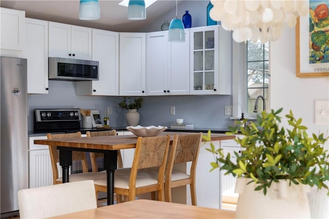 kitchen featuring pendant lighting, stainless steel appliances, and white cabinets