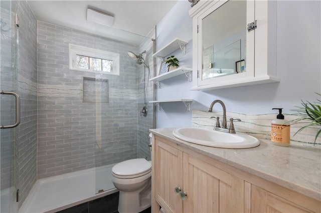 bathroom featuring vanity, toilet, and a shower with shower door