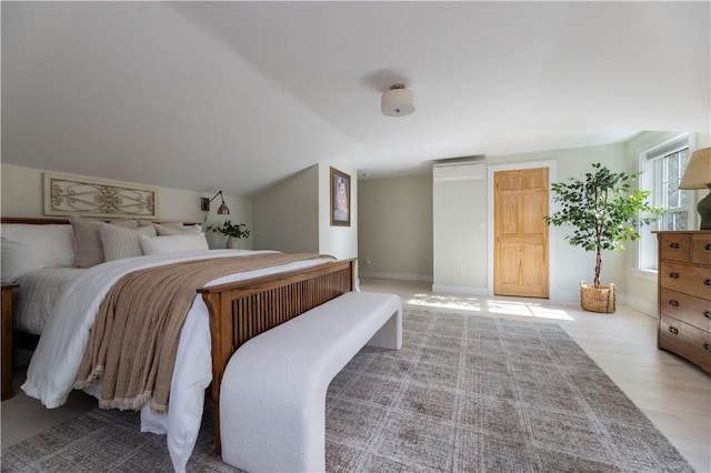 bedroom featuring vaulted ceiling and light wood-type flooring