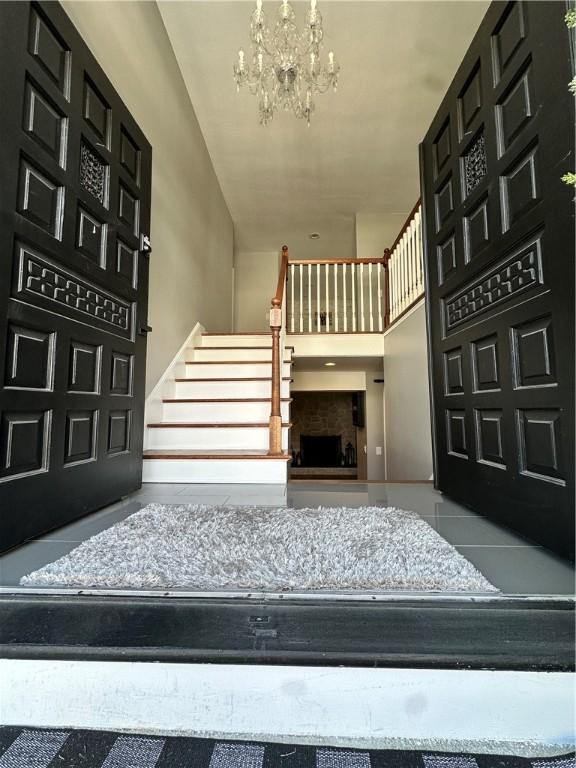 tiled entryway featuring a towering ceiling and an inviting chandelier