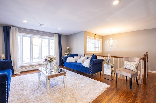 living room featuring a baseboard heating unit, dark hardwood / wood-style floors, and a chandelier