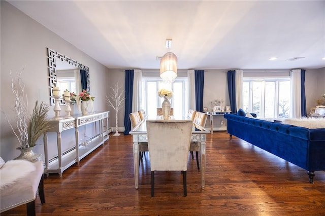 dining area with dark hardwood / wood-style flooring and baseboard heating