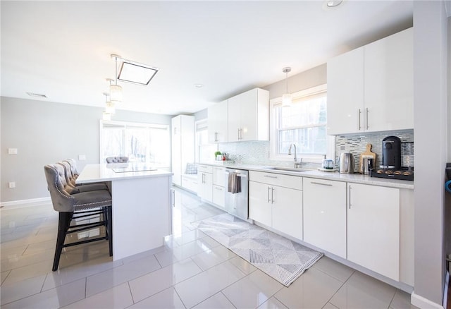 kitchen with sink, white cabinetry, a center island, hanging light fixtures, and stainless steel dishwasher