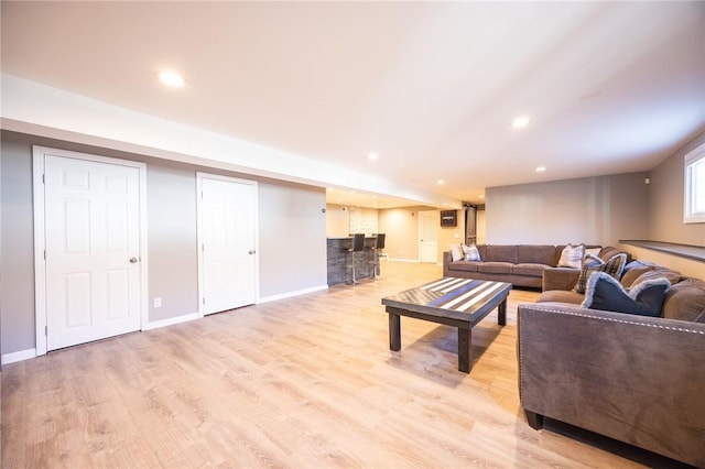 living room featuring indoor bar and light hardwood / wood-style flooring