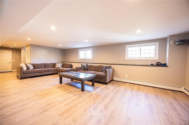 living room featuring a baseboard heating unit and light hardwood / wood-style flooring